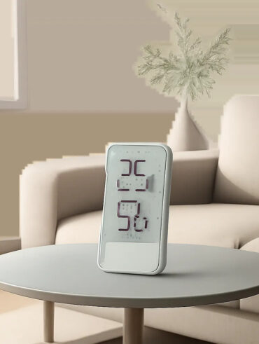 Un thermomètre d’intérieur élégant dans un décor contemporain, illustrant la mesure précise de la température ambiante. Une image pensée pour évoquer le confort, la maîtrise de l’air intérieur et la simplicité d’usage.