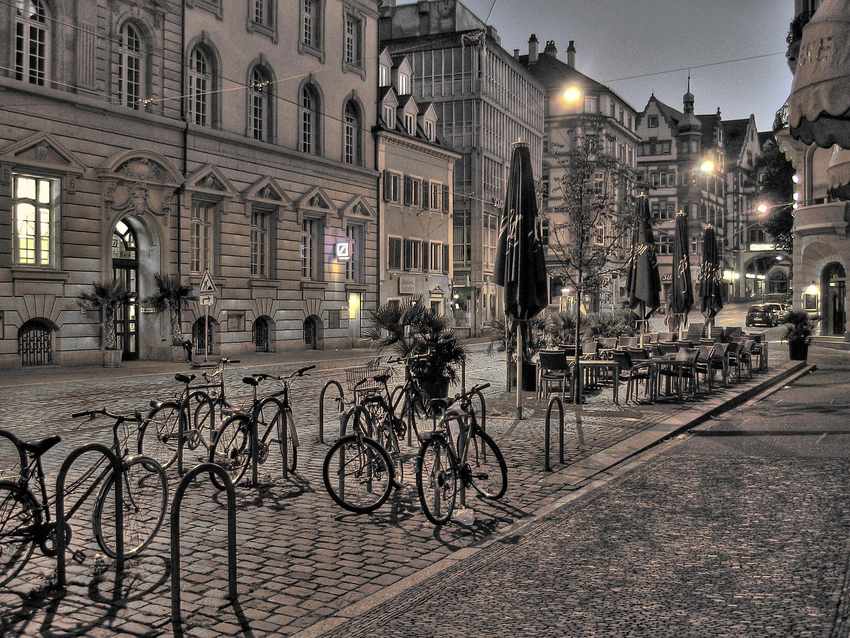 Bicycles à vélos, tables de café vides, façade historique, trottoir pavé Bicycles à vélos, tables de café vides, façade historique, trottoir pavé
