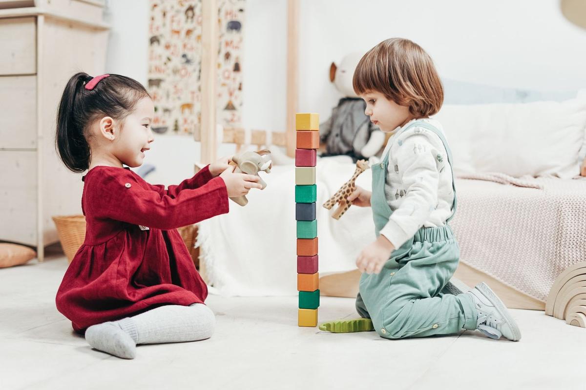 Enfants jouant avec des blocs colorés dans une chambre Enfants jouant avec des blocs colorés dans une chambre
