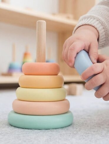 Un enfant joue avec un anneau empilable coloré sur un tapis