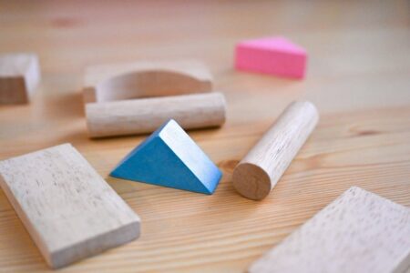 Blocs en bois, triangle bleu et pièces de puzzle sur une table