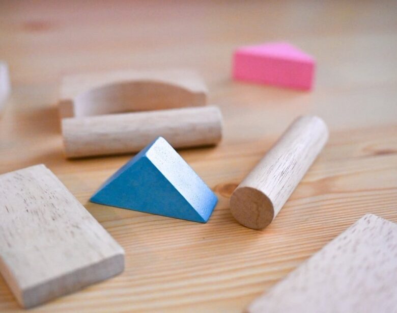 Blocs en bois, triangle bleu et pièces de puzzle sur une table